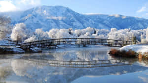 冬季河流上的雪橋與山景倒影 — 冬季風景 壁紙