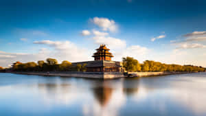 古代中國宮殿塔樓倒映在藍天白雲下的平靜水面上。 — 乾淨 壁紙