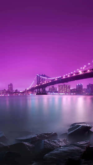 夜間城市天際線背景下，紫色燈光照亮的橋樑和水面。 — 塔橋 壁紙