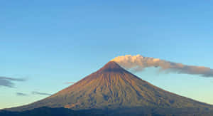 火山在日出中發光，山頂有雲 — 菲律賓 壁紙