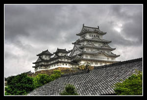 山頂上的白色日本城堡，深色瓦片屋頂和綠樹，多雲天空。 — 城堡動畫 壁紙