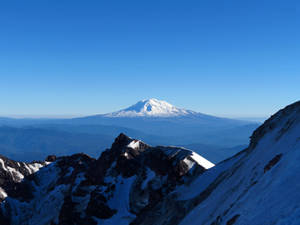 清澈藍天下的雪山峰頂，前景崎嶇的地形 — 美麗的藍色 壁紙