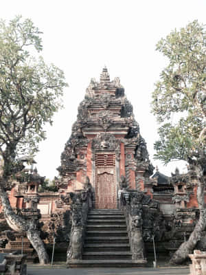 峇里島寺廟，帶有精細的石雕和周圍的樹木 — 廟宇 壁紙