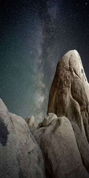 在可見銀河的繁星夜空下，崎嶇的岩層。 — 3D 自然 壁紙