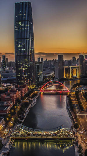 黃昏時分的城市天際線，紅色橋樑和高樓大廈倒映在河中。 — 塔橋 壁紙