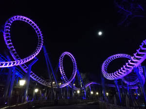 夜晚明亮的月亮下，紫色燈光雲霄飛車的迴圈。 — 雲霄飛車 壁紙