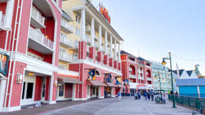沿著木製木板路的紅白度假村建築，有人行走。 — 海灘度假 壁紙