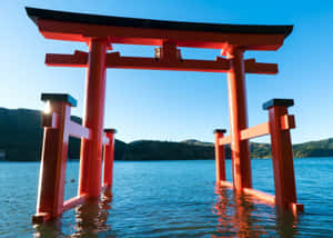 水中的紅色鳥居，背景有山和晴朗天空 — 東京喰種風格 壁紙