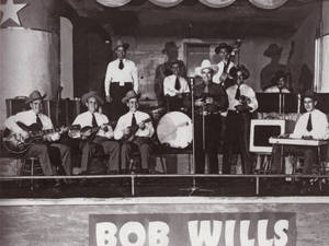 Bob Wills及其樂隊在黑白舞台上演奏樂器。 — 好萊塢 壁紙