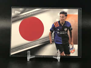 帶有日本國旗設計的久保裕也足球交換卡展示在支架上。 — 日式 壁紙