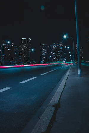 夜間城市街道，有移動車輛的紅色光軌和照明建築。 — 黑夜 壁紙