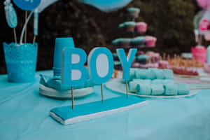 嬰兒派對上的藍色「BOY」標誌，桌上擺放著粉彩甜點。 — 派對 壁紙