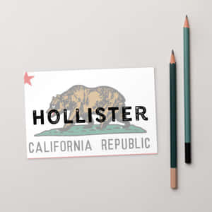 灰色背景上帶有熊圖案和兩支彩色鉛筆的Hollister品牌卡。 — 1:1 壁紙
