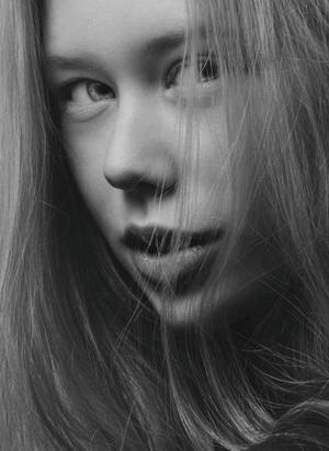 年輕女性的黑白特寫肖像，頭髮勾勒臉部輪廓。 — 害羞 壁紙