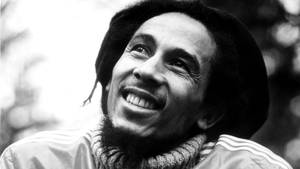 Bob Marley 帶著辮子和 Adidas 外套在戶外微笑。 — 巴布·馬利語錄 壁紙