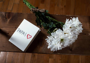 寫有「PAPAI」和心形的便條，旁邊有白色花，在木上。 — 花朵 壁紙