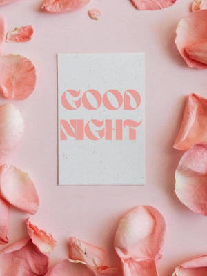 一張寫有 'GOOD NIGHT' 的粉紅色卡片，被玫瑰花瓣環繞，營造舒緩的睡前氛圍。 — 晚安 壁紙