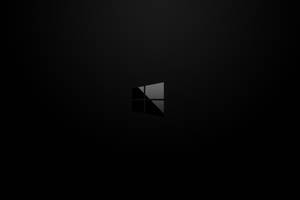 Windows標誌居中於深色紋理背景上，帶有漸變燈光。 — 簡約暗黑美學 壁紙