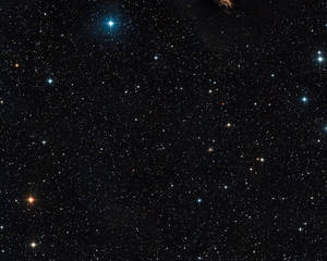 繁星點點的夜空，明亮的藍色和橙色星星散落在黑色虛空中。 — 星星 壁紙