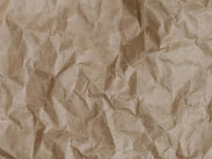 帶有深深摺痕和柔和陰影的皺巴巴棕色紙張質感。 — Old Paper 壁紙