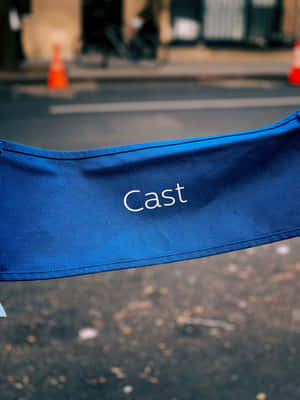 城市街道上帶有「Cast」文字的藍色導演椅。 — iPad 第9代 壁紙