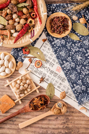 各種乾燥香料和香草排列在木質表面上，搭配傳統紙張和布料。 — 烹飪 壁紙