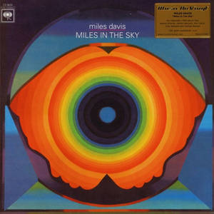 為 Miles Davis 專輯設計的藍色背景上帶有彩虹環的迷幻眼睛藝術。 — 音樂 壁紙