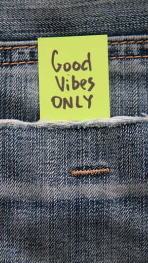 一張黃色便利貼，上面寫著 Good Vibes ONLY，放在牛仔褲口袋裡。 — 丹寧 壁紙