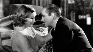 一男一女穿著1930年代的服裝，在昏暗的房間裡分享親密時刻。 — 演員 壁紙