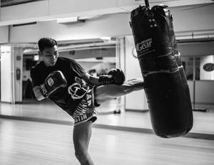 男子在健身房用重型沙袋練習踢拳。 — 運動 壁紙