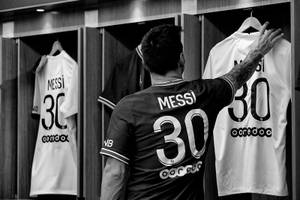 身穿30號球衣的足球員梅西在更衣室衣架上觸摸自己的名字。