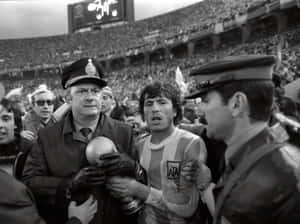 阿根廷足球運動員在體育館人群中與警察一起高舉獎盃。 — FIFA 世界盃 壁紙