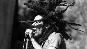 Bob Marley 留著長髮辮對著麥克風唱歌的黑白照片。 — 巴布·馬利語錄 壁紙