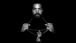 Ice Cube 在黑白工作室肖像中舉起一條帶有他名字吊墜的鏈條。 — 布萊德彼特 壁紙