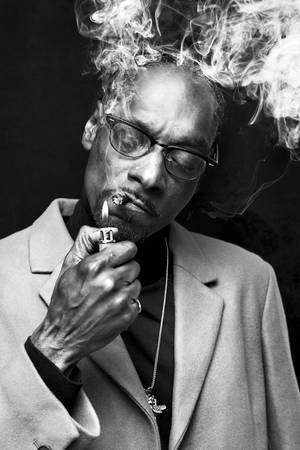 Snoop Dogg 穿著外套抽煙，煙霧在他頭頂升起。 — 抽菸 壁紙