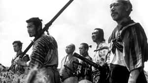 六名身穿傳統服飾的武士站在田野中，手持步槍和刀劍。 — 黑川伊佐那 壁紙