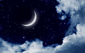 新月和星星在黑暗的夜空中從雲層間探出頭來。 — 月夜星空 壁紙