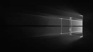 一扇窗戶，光線穿過黑暗房間中的灰塵。 — 黑色 Windows 10 壁紙