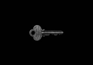 一把帶有雕刻文字的復古金屬鑰匙，背景為黑色。 — 銀色 壁紙