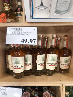 商店中擺滿 El Tequileno Añejo 龍舌蘭酒瓶的貨架。 — 3:4 壁紙