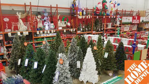 Home Depot 商店通道中展示的聖誕樹和節日裝飾品。 — 好市多 壁紙