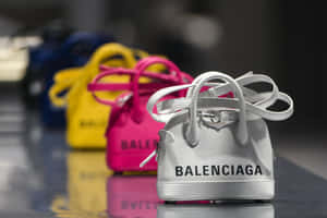 色彩繽紛的Balenciaga手袋在店內展示，拋光地板上反射出倒影。 — 巴黎世家 壁紙