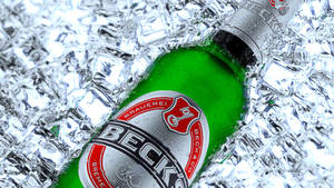 冰涼的綠色Beck's啤酒瓶被碎冰環繞。 — 德國 壁紙