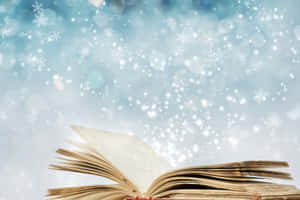 一本打開的書，雪花在神奇的藍色散景背景中飄落。 — 閱讀 壁紙