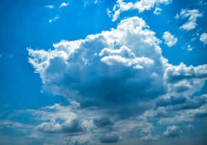 廣闊的藍天，有一朵巨大的蓬鬆白雲，陽光穿透其中。 — 暴風 壁紙