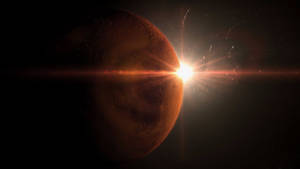 一顆紅色行星沐浴在燦爛的陽光中，背景是黑暗的星空。 — 火星人布魯諾 壁紙