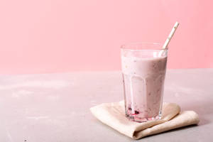 粉紅莓果 smoothie 於玻璃杯連吸管，置於米色餐巾上，襯以粉紅背景 — 果昔 壁紙