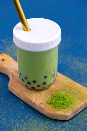 抹茶泡泡茶配金色吸管，置於木板上，背景為藍色 — Huawei MatePad 11.5 (2025) 壁紙
