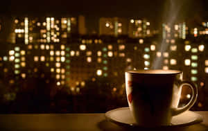 窗台上的一杯冒煙的茶，背景是模糊的城市夜景。 — 茶 壁紙
