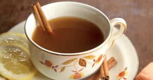 一杯香料茶，搭配檸檬和肉桂，放在花卉碟子上。 — 茶 壁紙